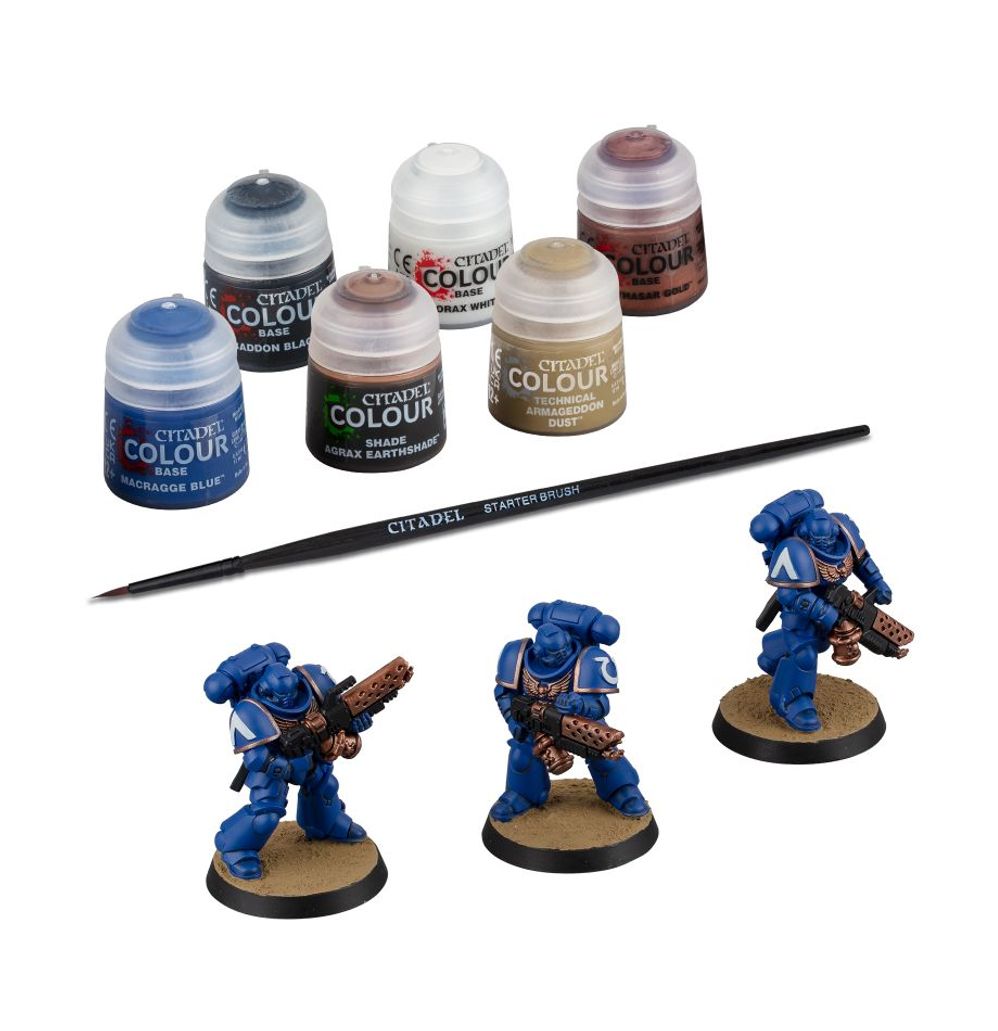 Miniature painting set with Citadel paint jars and miniatures on a white background
